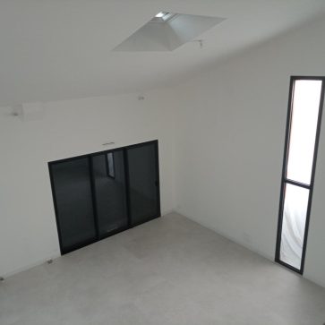 Aménagement d'un espace avec grandes baies vitrées, lumière naturelle et sol en carrelage.